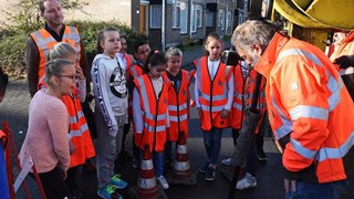 Leerlingen van De Rank inspecteren saen met wethouder Bashara het riool, onder toeziend oog van toezichthouder Ad Kunst